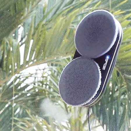HOBOT 388 window cleaning robot cleaning a window, palm trees outside